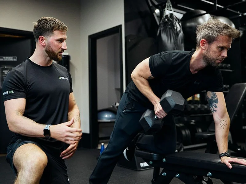 Personal trainer working one-on-one with a client on strength exercises